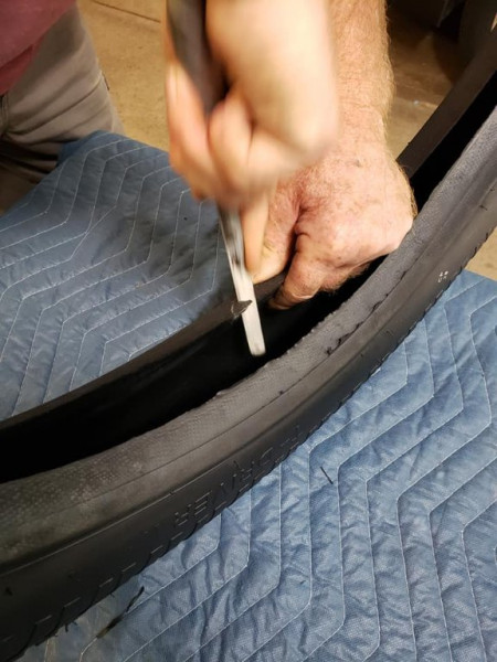 Newer clincher tires get a little close inside the rim, so a relief cut is made for the brass stem.