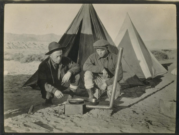 Mr Billyan and Mr Abbott by stove Death Valley auto trip January 1926 .png