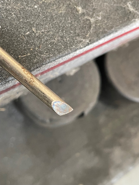 Sharp hollow ground angled tip on my homemade staple puller made getting behind the staple relatively easy. Quenching the tip in water immediately after grinding made it hard enough for reasonable durability.